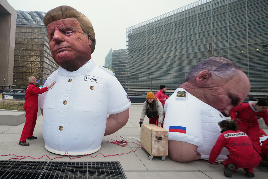 Aktivister jobbar med två uppblåsbara dockor av Donald Trump och Vladimir Putin.