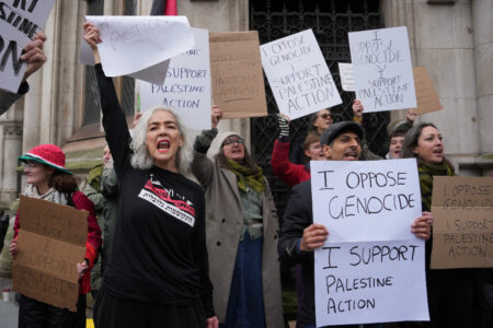 Flera personer håller upp handskrivna plakat.