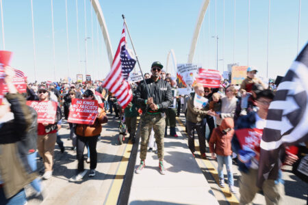 Kymone Freeman håller i amerikansk flagga under en No Kingsdemonstration.