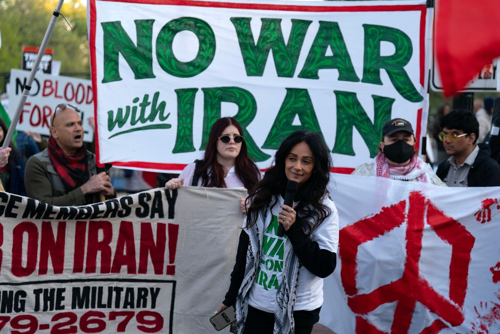 Demonstranter med banderoller protesterar mot kriget i Iran.