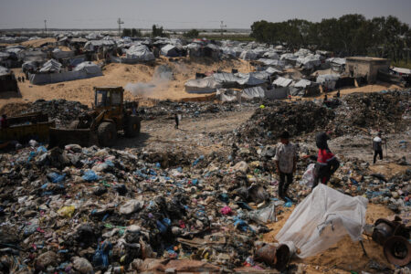 Palestinska barn på en soptipp intill ett tältläger i Gaza.