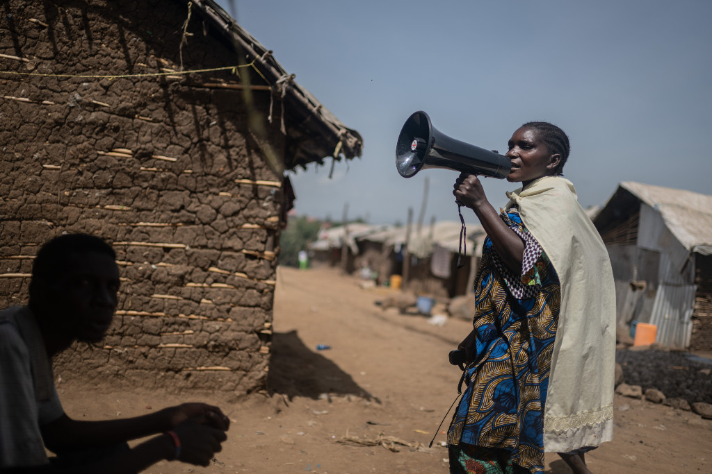 Kvinna med megafon i by i Kongo-Kinshasa.