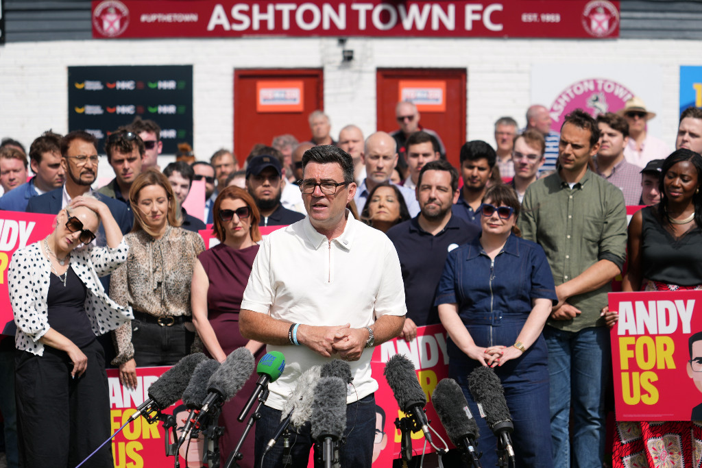 Andy Burnham talar med supportrar runt omkring sig.