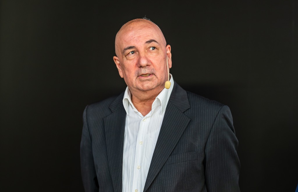 Kurdo Baksi i kavaj mot mörk bakgrund.