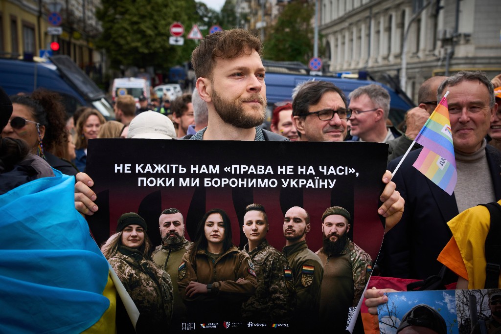 Man håller i affisch med bilder på ukrainska soldater.