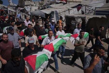 Sörjande bär på kistor insvepta i palestinska flaggor.
