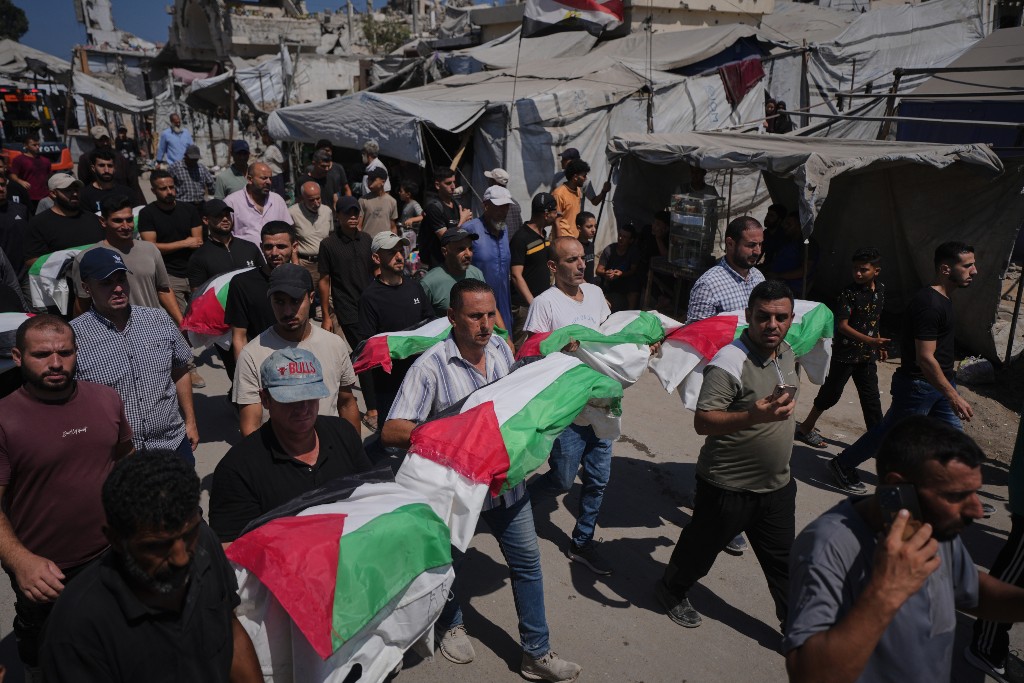 Sörjande bär på kistor insvepta i palestinska flaggor.