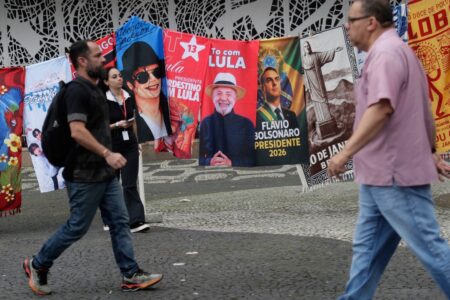 Folk passerar valaffischer i Rio de Janeiro.