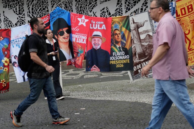 Folk passerar valaffischer i Rio de Janeiro.