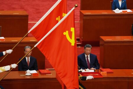 Kinas president Xi Jinping med Kinas flagga i förgrunden.