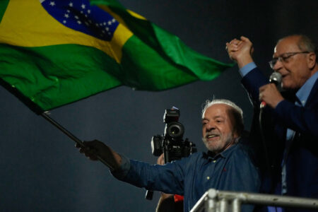 Brasiliens president Lula da Silva håller i en brasiliansk flagga och firar med sin vicepresident Geraldo Alckmin.